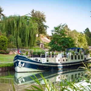 The Saint Louis hotel barge gliding along the tree-lined Canal de Garonne in Bordeaux France
