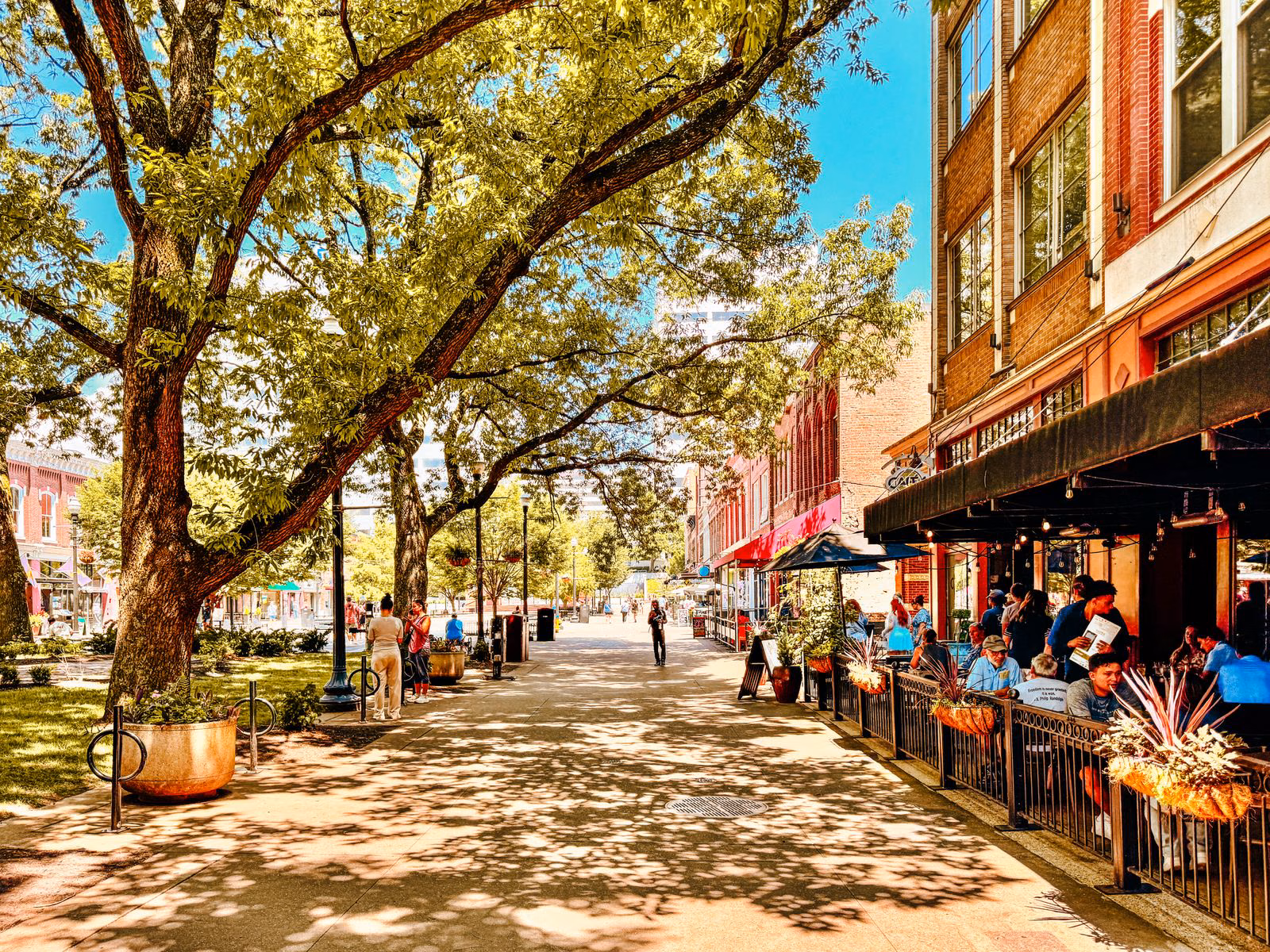 Where to Stay in Knoxville, TN (and the Airport Airbnb I'd Book Again) 1 Restaurant patios and outdoor diners under shade trees on a brick-paved street in downtown Knoxville