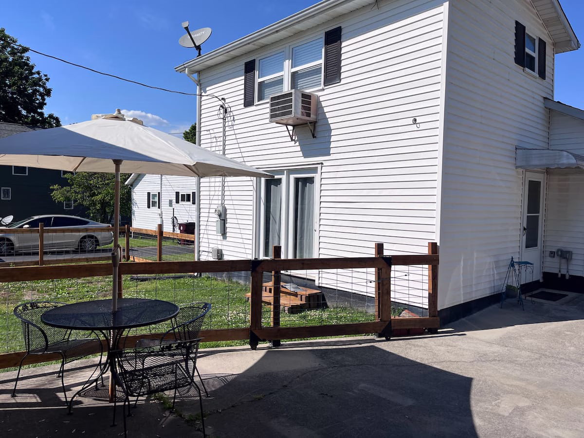 Where to Stay in Knoxville, TN (and the Airport Airbnb I'd Book Again) 7 Patio table with an umbrella beside the driveway and the fenced backyard at Parkside Loft in Alcoa