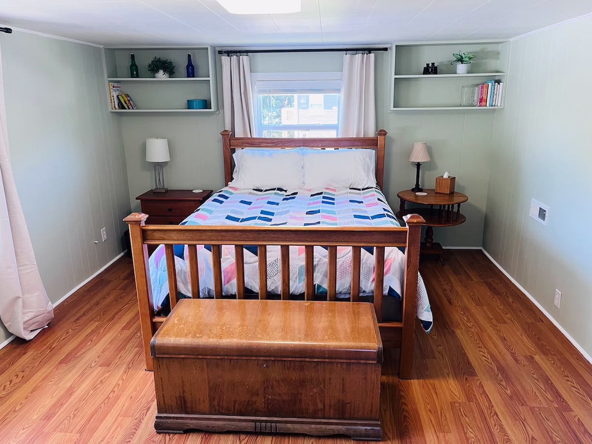 Where to Stay in Knoxville, TN (and the Airport Airbnb I'd Book Again) 6 Queen bed with a wooden frame and a geometric quilt in the upstairs loft bedroom at Parkside Loft